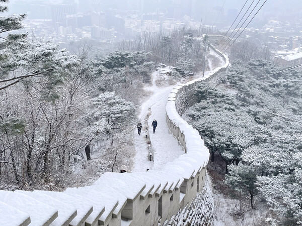 사진= 크리스마스인 25일 눈이 내린 서울 인왕산 성곽길을 시민들이 걷고 있다./연합뉴스